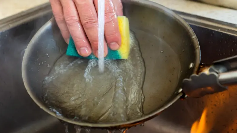 Secando la sartén sobre el fuego de la cocina para evitar el óxido y aplicando una gota de aceite.