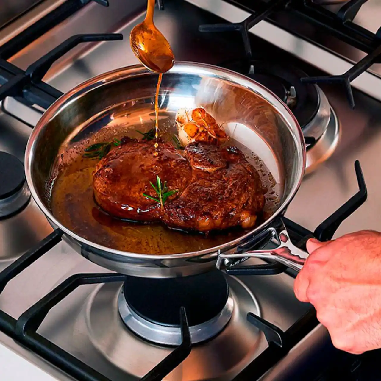 Filete de salmón cocinándose en la sartén de acero sin pegarse a la superficie.