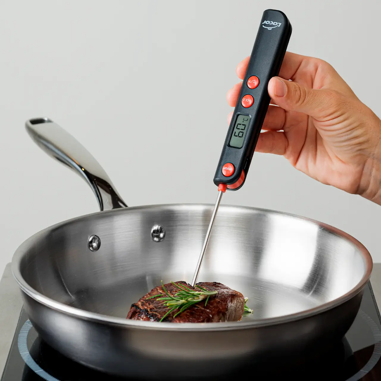 Termómetro de infrarrojos midiendo la temperatura de una sartén sobre el fuego.