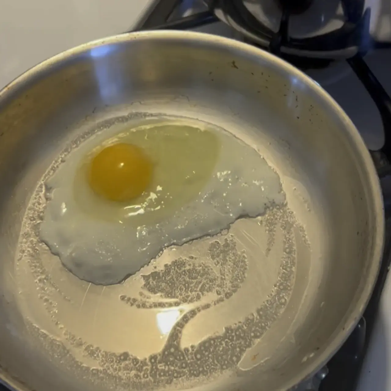 Diagrama de proteínas de huevo enlazándose a la superficie metálica de una sartén.