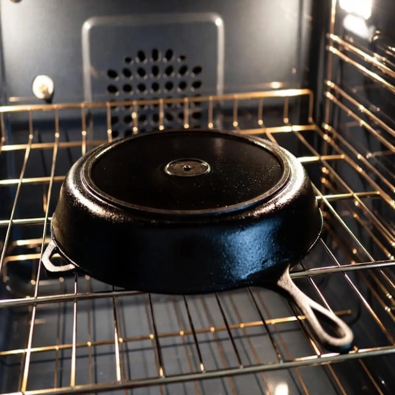Sartén de hierro colocada boca abajo en la rejilla del horno para polimerizar el aceite a alta temperatura