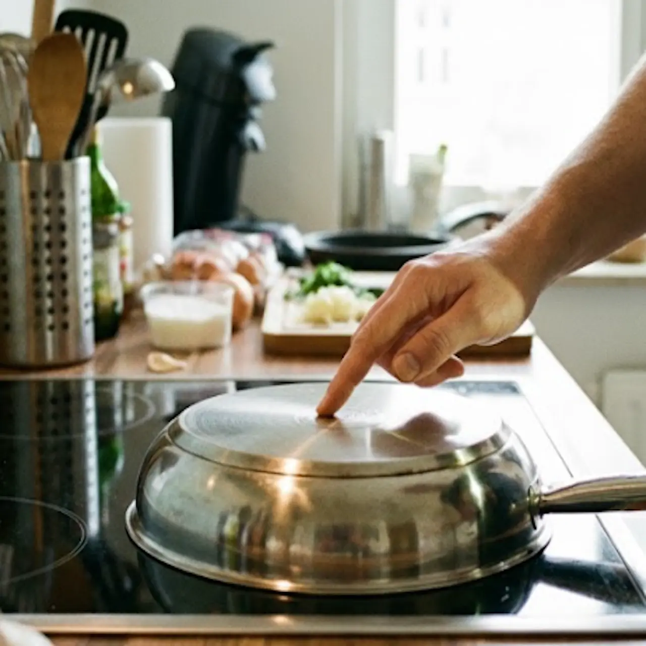 Comprobando que la base de una sartén es plana sobre la vitrocerámica antes de cocinar.